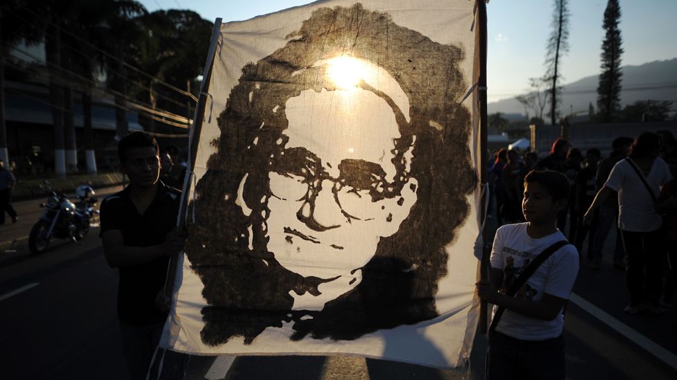 Procesión con una tela en la que está pintado el rostro de monseñor Romero