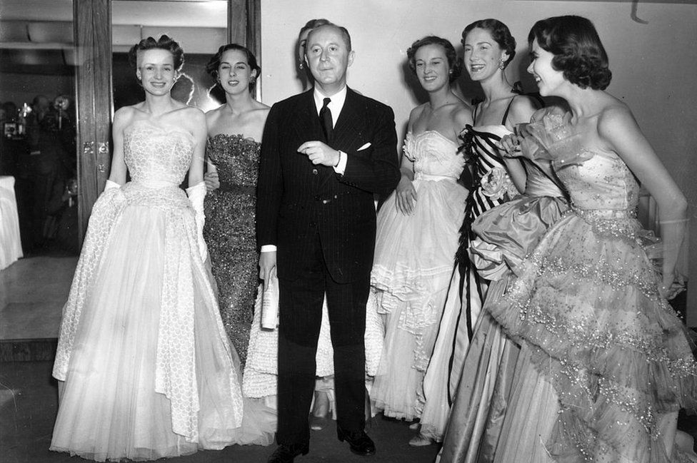Fashion couturier Christian Dior (1905 - 1957), designer of the 'New Look' and the 'A-line', with six of his models after a fashion parade at the Savoy Hotel, London: 25 April 1950