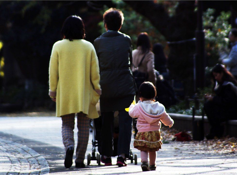 На этом снимке, сделанном 12 декабря 2015 года, изображена семья, гуляющая в парке в Токио. На этой неделе верховный суд Японии вынесет решение по паре семейных законов XIX века, которые критики сочтут сексистскими и неуместными