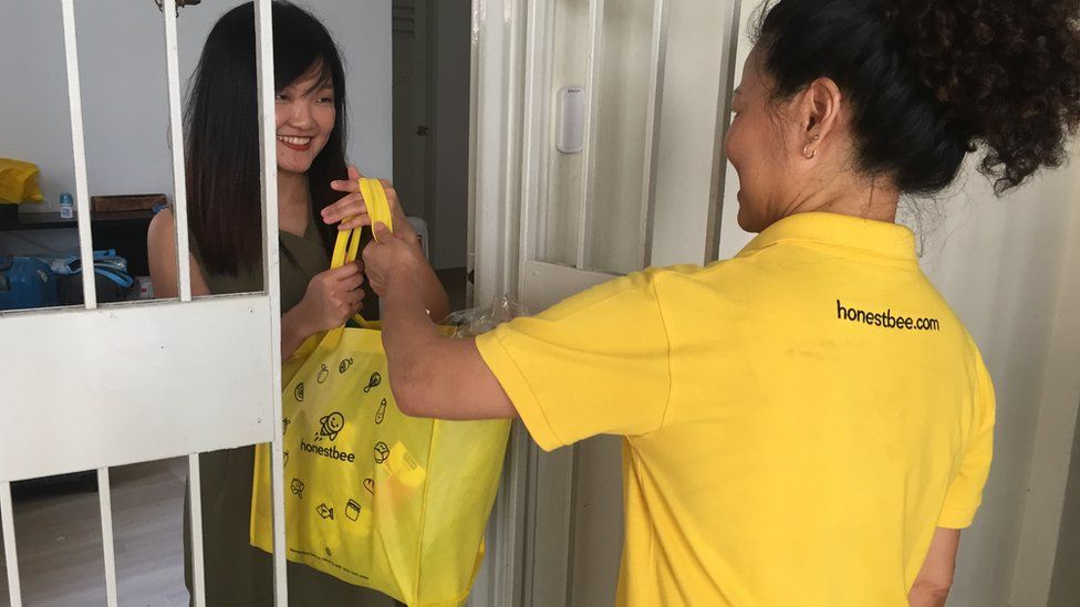 HonestBee delivery person handing over bag to customer