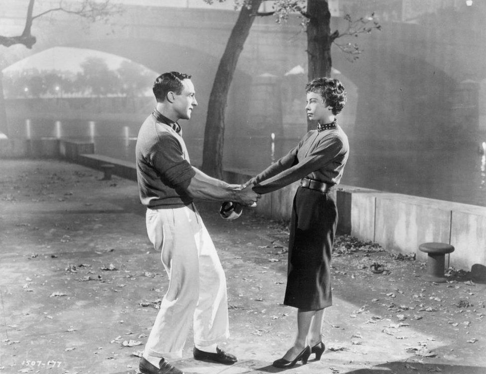 Gene Kelly hold Leslie Caron's arms in a scene from An American In Paris