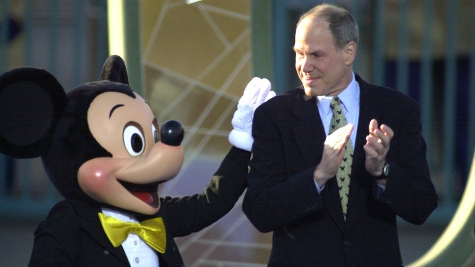 Michael Eisner, CEO and chairman of the Walt Disney Company, gets a pat on the back from Mickey Mouse in 2001