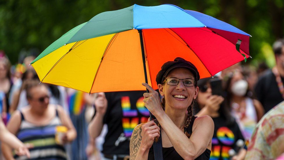A woman holding a colourful umbrella