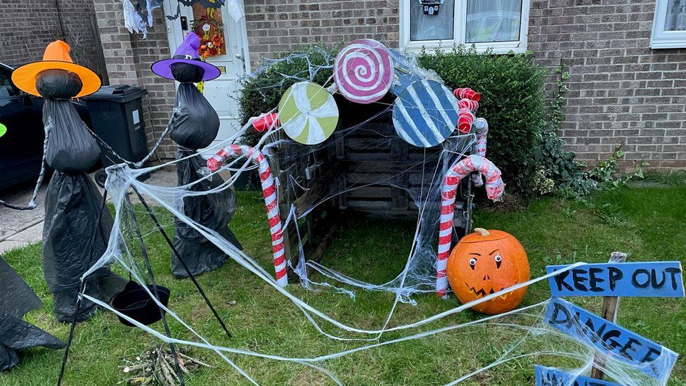 Halloween display with witches and a gingerbread house and some cobwebs