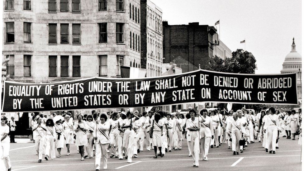 Women carry a large banner down Pennsylvania Avenue demanding equality, 26 August 1977