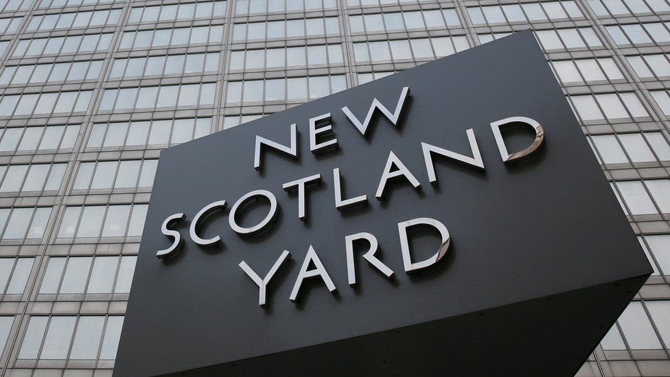 The rotating triangular sign is seen outside New Scotland Yard in central London