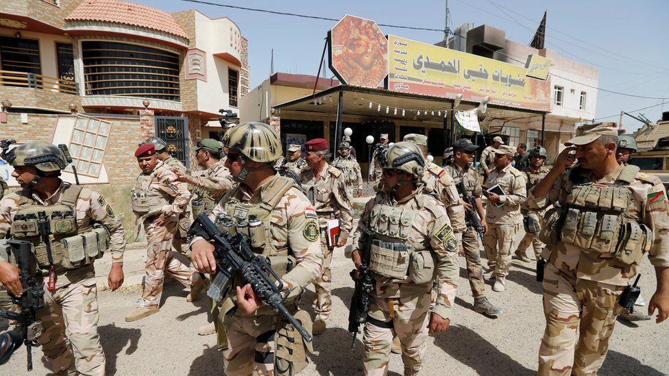 Iraqi soldiers walk through central Falluja (17 June 2016)