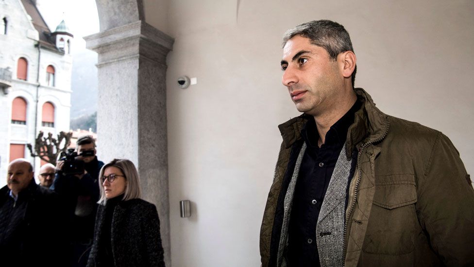 Cosar, clean-shaven and in civilian clothing, arrives at the Federal Criminal Court of Switzerland in Bellinzona