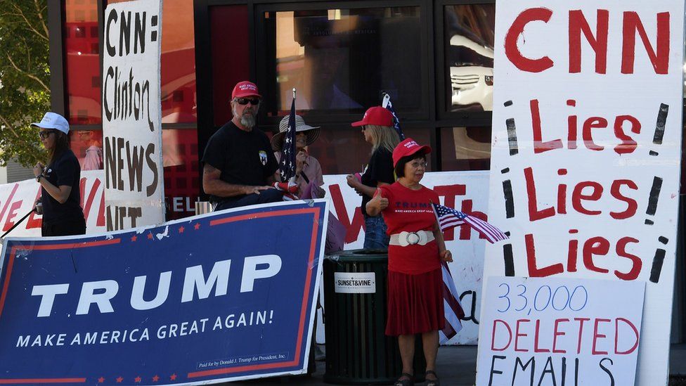 Pro-Trump supporters carrying signs including one saying CNN Lies Lies Lies