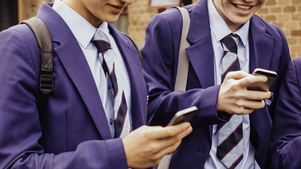 Male pupils on mobile phones