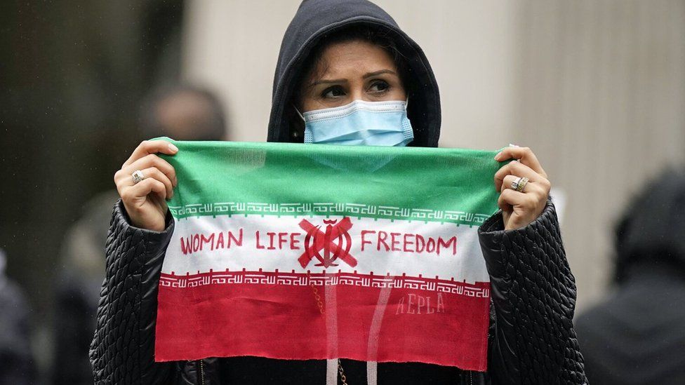 Женщина держит знак протеста на Трафальгарской площади в Лондоне (29.10.22)