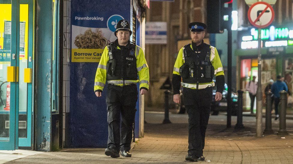 Two police officers in the streets wearing hi-vis jackets