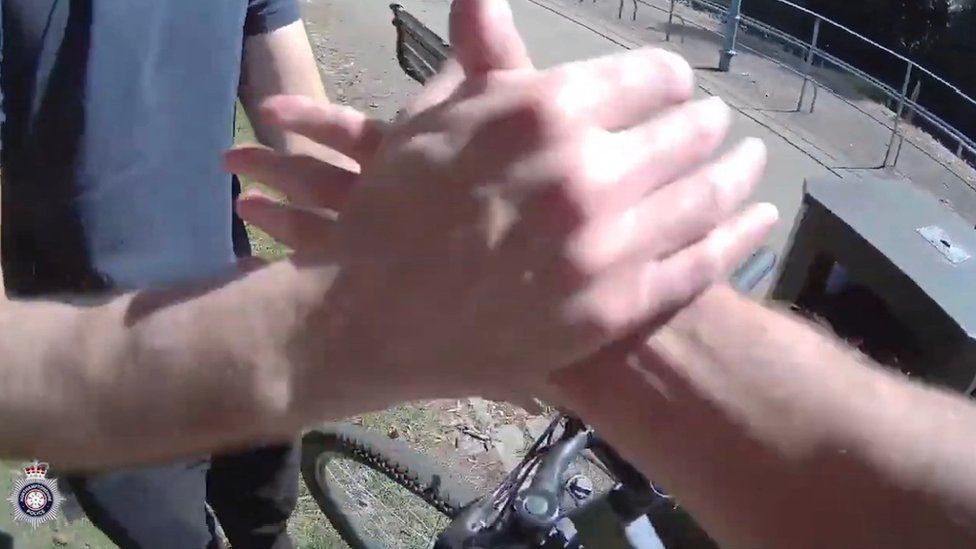 A close-up of two people shaking hands with a bike in the background