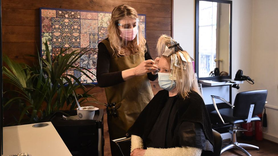 Amanda Sidley, owner of Bronte's Hair Boutique, cuts a customers hair after reopening on April 12, 2021 in Leek, England