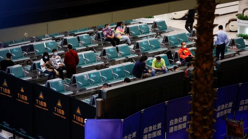 Relatives of those on board the passenger wait in a sectioned-off area at Guangzhou International Airport