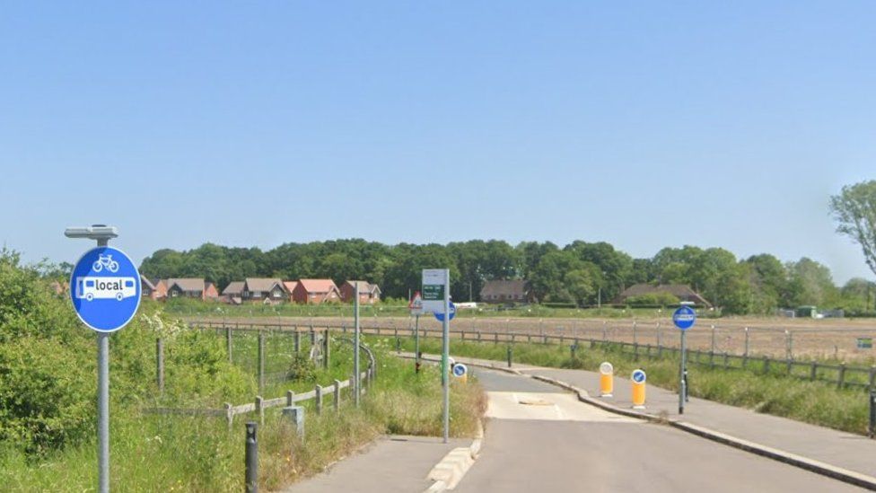 Development land off Hyde End Lane in Shinfield with new houses in the distance