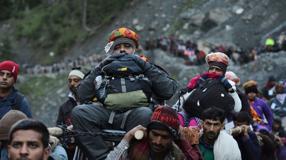 An Indian Hindu devotee is carried by Kashmiri porters during the start of the annual journey from Baltal Base Camp to the holy Amarnath Cave shrine in Baltal near Srinagar on July 2, 2015