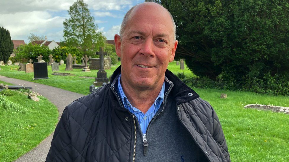 Image of Nick Wood standing in Arnos Vale Cemetery with trees behind him