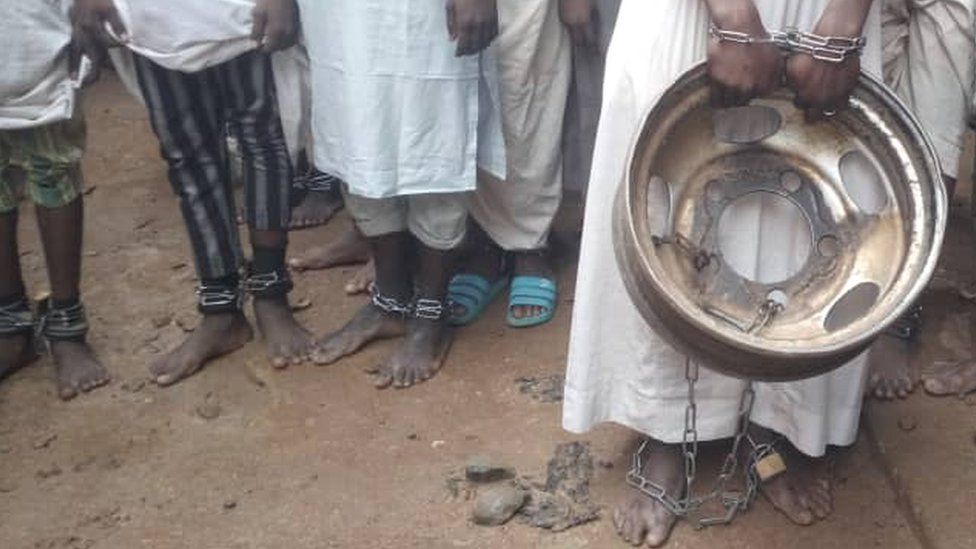 Видны пленники с цепями на лодыжках, когда полиция освобождает их