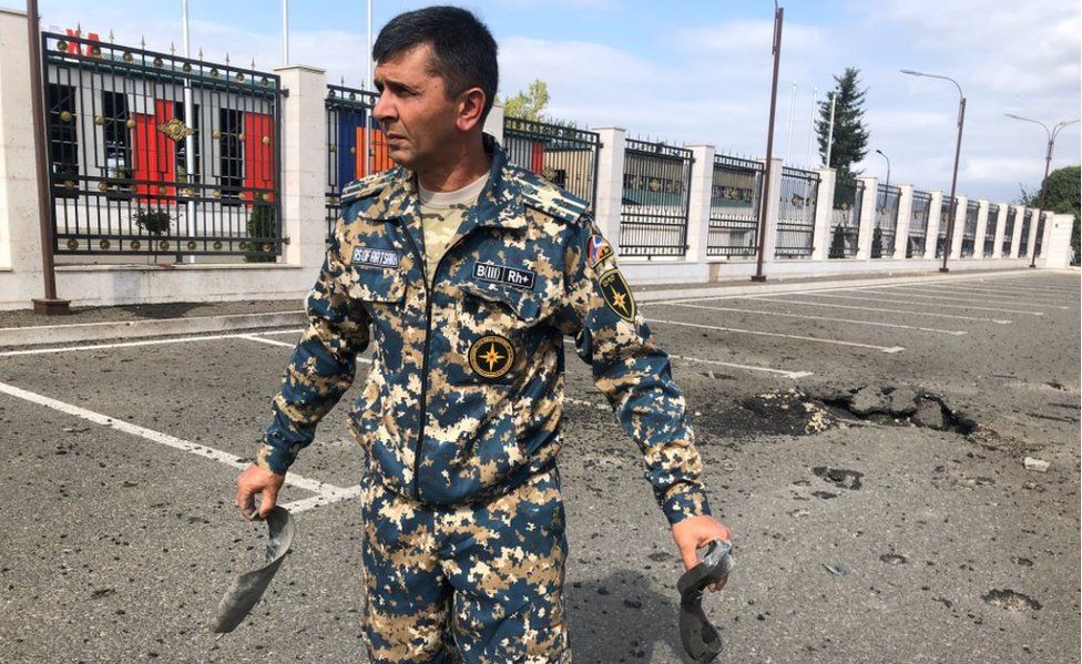 An officer in Stepanakert shows parts of a rocket that came down near the emergency service department