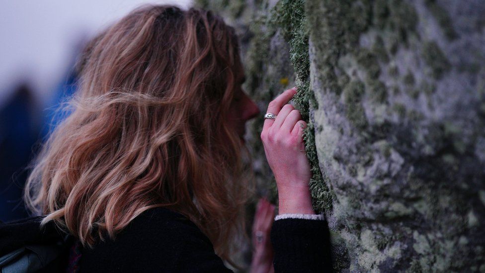 A women touching Stonehenge