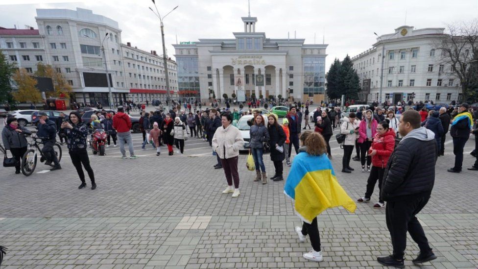 People with Ukrainian flags fill a square in the Ukrainian city of Kherson