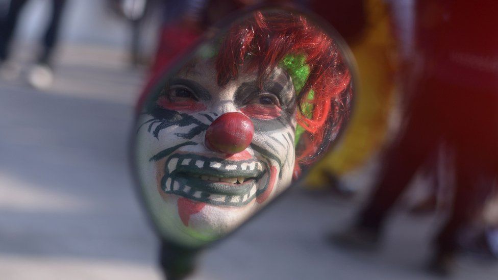 A clown's reflection in a mirror