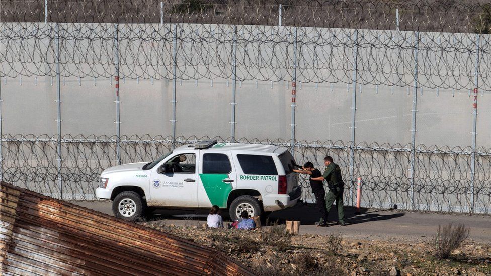 Illegal immigrants being arrested by US border guards after breaking into the US