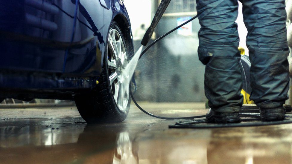 A man jet washing a car