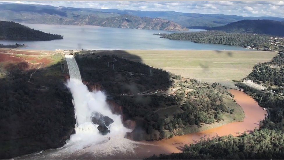 Water flows over an emergency spillway of the Oroville Dam in California, 11 February 2017