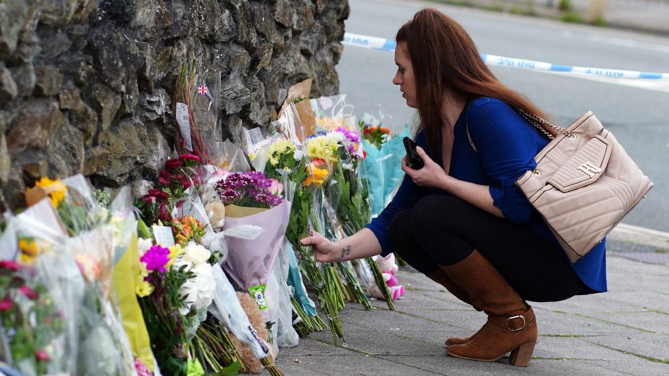 People leave flowers in the Keyham area of Plymouth after five people died in a shooting on 12 August 2021