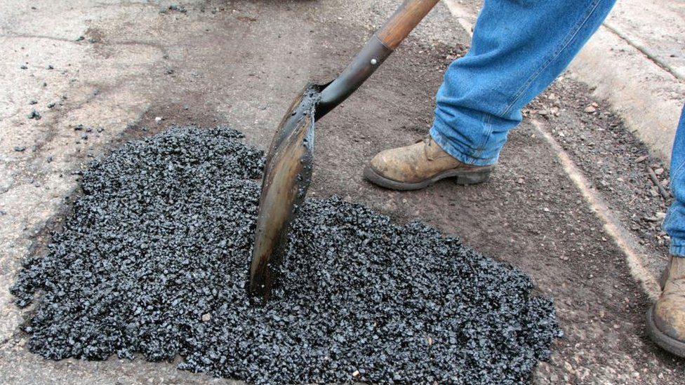 Worker filling in pothole