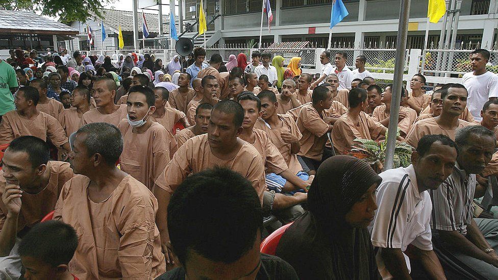 Thai detainees sit in the courtyard of the Narathiwat jail