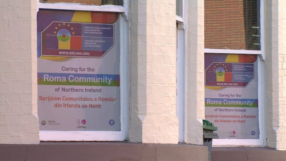Signs in thee windows of the Romanian Roma Community Association of Northern Ireland offices