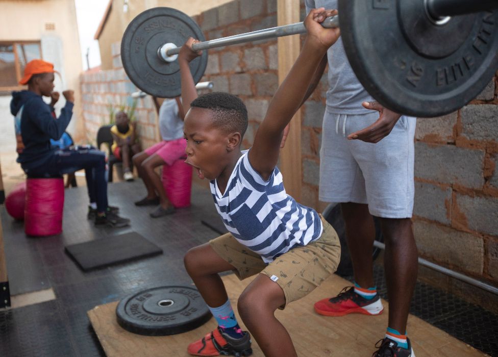 A young boy lifts heavy weights at a training session in Soweto, South Africa - Thursday 27 January 2022
