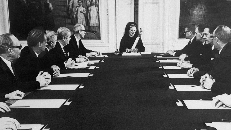 Queen Margrethe II sits at the end of a long table - with only men joining her