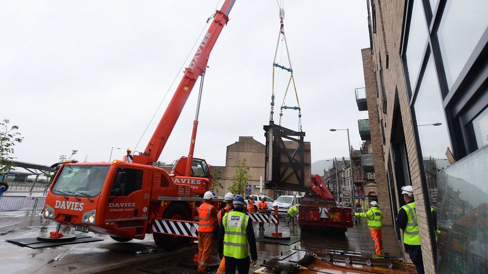 The Banksy being moved into the gallery by a crane