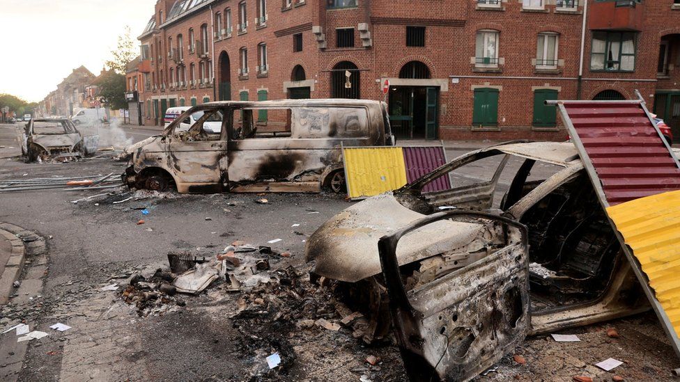 Blick auf eine Straße mit brennenden Autos bei nächtlichen Zusammenstößen zwischen Demonstranten und der Polizei im Stadtteil Alma in Roubaix, Nordfrankreich