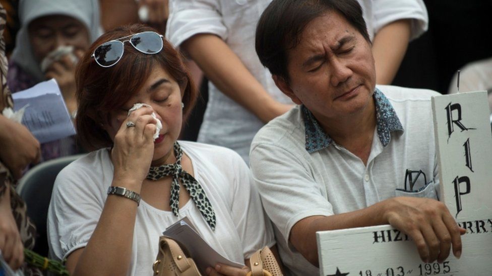 The parents of one of the victims of the Lion Air crash attend their son's funeral