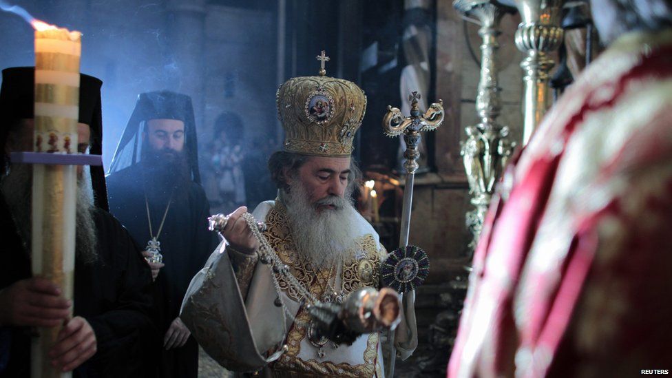Greek Orthodox Patriarch of Jerusalem Metropolitan Theophilos (C) walks during Easter service in the Church of the Holy Sepulchre in Jerusalem's Old City
