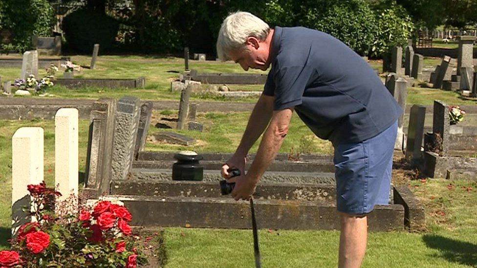 Mick McCann taking pictures of graves