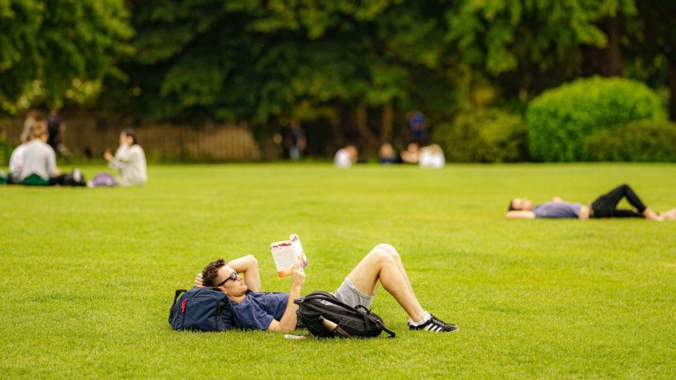 People relax in the sun on the grass at the Royal Crescent, Bath. Picture date: Monday June 13, 2022.