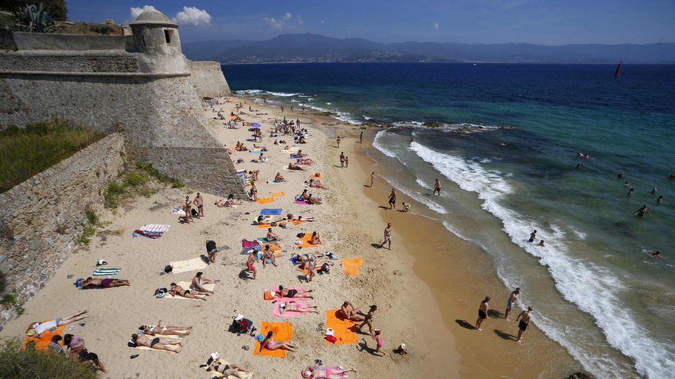 туристы проводят день на пляже Цитадель в центре Аяччо на французском средиземноморском острове Корсика