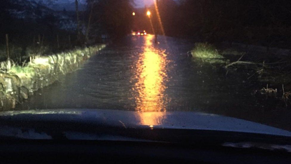 Car driving down a flooded street