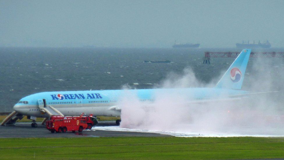 Smokes and foam sprayed by fire crews at Haneda airport, rises from a Korean Air plane on the tarmac on (27 May 2016)