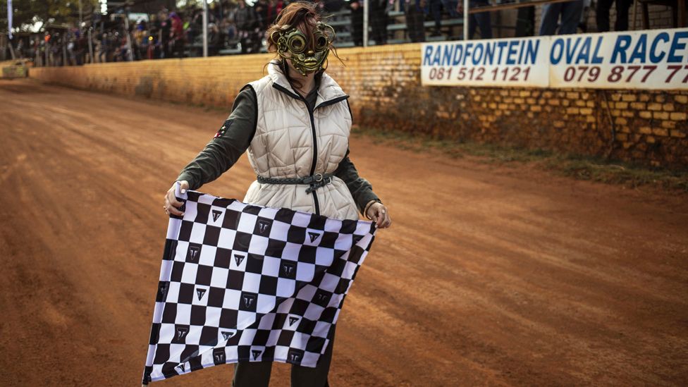 A masked woman with a flag at the Stof Skop race meeting at the Randfontein Raceway, Johannesburg, South Africa -Saturday 12 August 2023