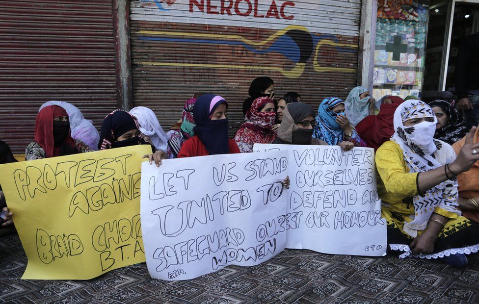 Kashmiri Muslim women hold signs protesting against "braid chopping"