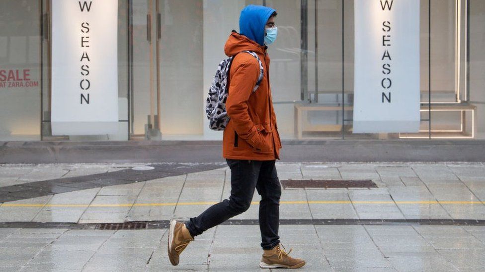 Man walking in front of closed shop.