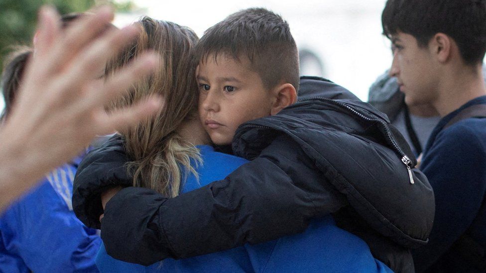 Joanna, a migrant from Central America, carries her son
