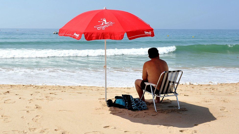 Мужчина на пляже в Прайя-да-Луз в Португалии